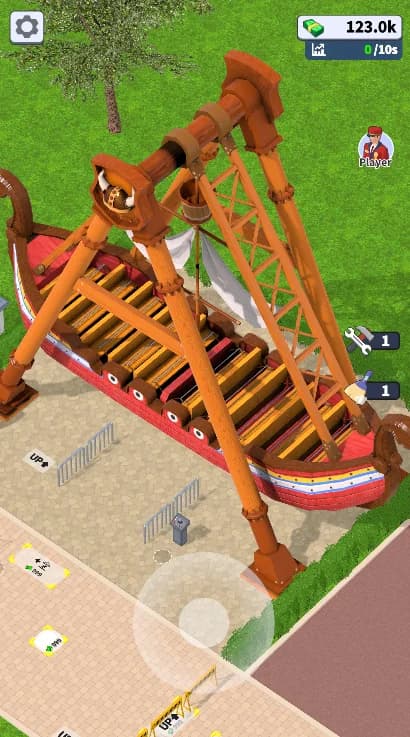 A pirate-ship swing already in Theme Park Manager: weathered timber planks, a heavy orange steel A-frame, painted hull trim, queue rails and a guest walking past, seen through the game's elevated diagonal camera